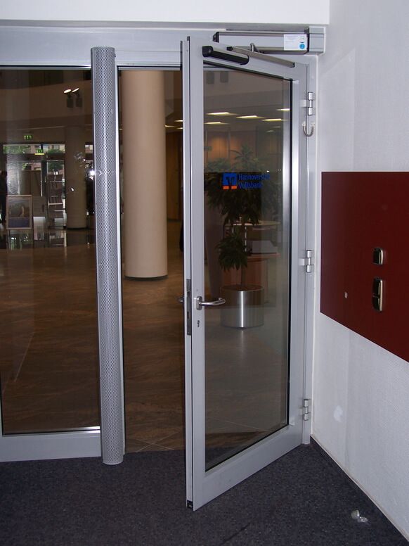 Halb geöffnete Tür mit Drehflügelantrieb DORMA ED 250 in der Volksbank Seelze.