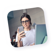 Lächelnde Frau, die aufmerksam auf ihr Handy schaut.